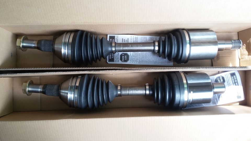 Two new CV axles in a cardboard box, with instructions