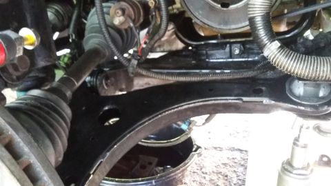 Car's front suspension and engine bay with a drain pan underneath