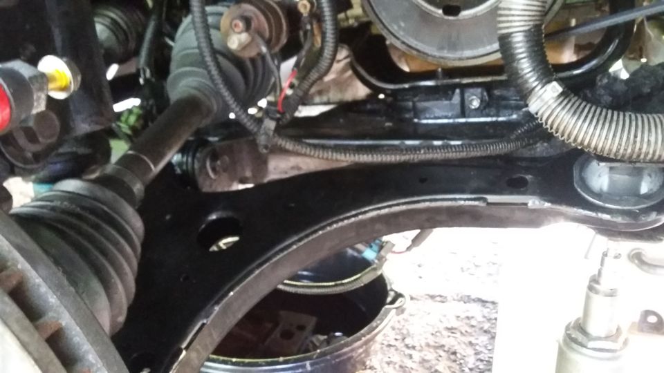 Car's front suspension and engine bay with a drain pan underneath