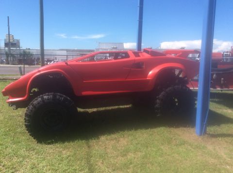 1992 Ford Bronco - This red off-road vehicle has a distinctive body shape and is equipped with large tires for off-road use.