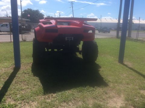 1992 Ford Bronco - This heavily modified vehicle features a prominent rear spoiler and massive tires, giving it a unique monster truck appearance.