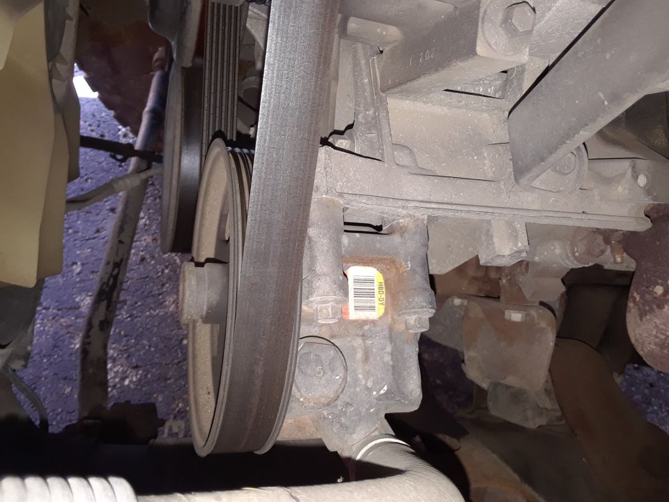 Close-up of engine belt and power steering pump with a barcode sticker