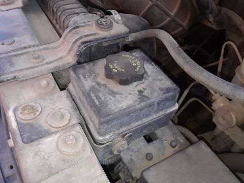 1999 Ford E250 - Close-up view of engine components, including the power steering fluid reservoir.