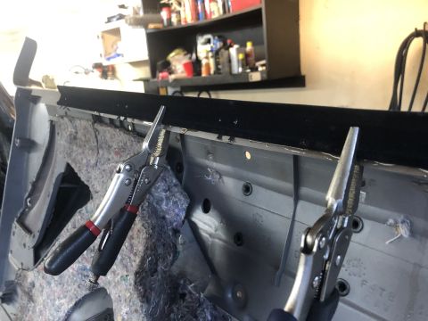 1995 Ford Bronco - Door panel interior being worked on, with insulation visible and locking pliers holding a section.