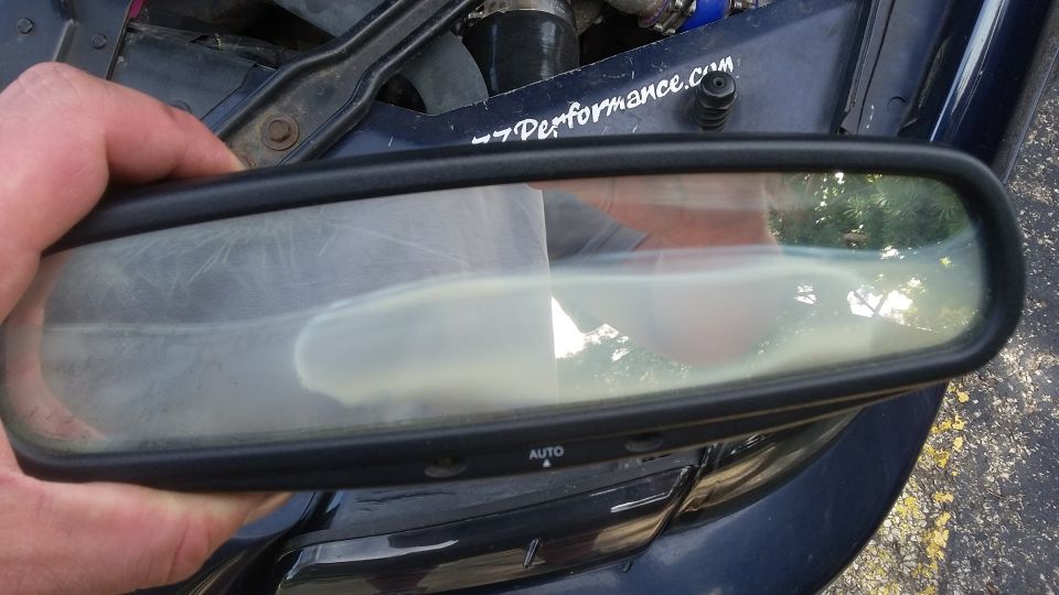 Rear-view mirror with 'AUTO' button and "-7performance.com" sticker on car hood