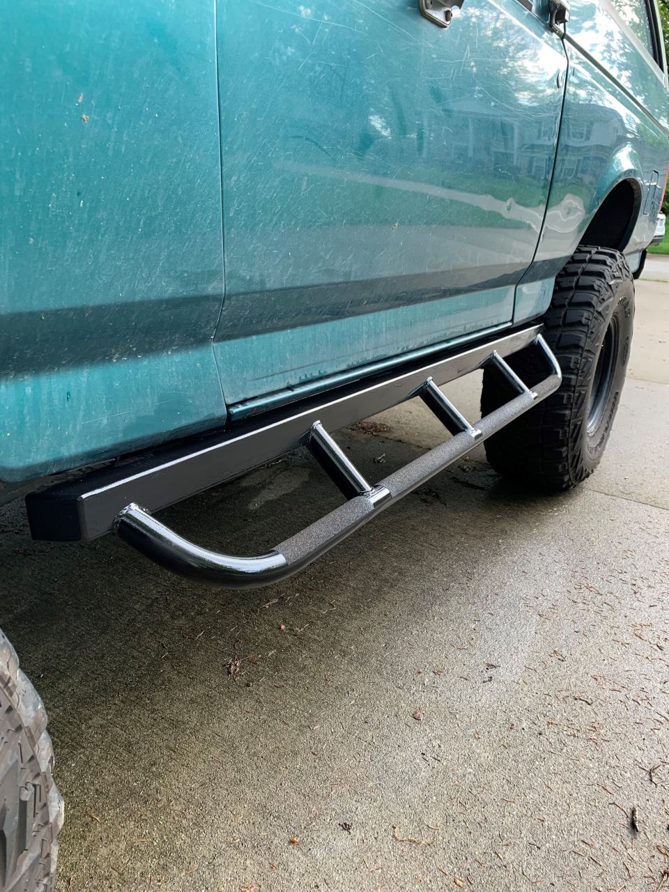 1996 Ford Bronco side view showing aftermarket tubular step bars and large tires