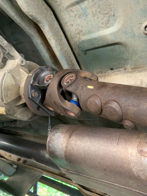 1996 Ford Bronco - Underside view of a vehicle's driveshaft and differential assembly, showing wear and components.
