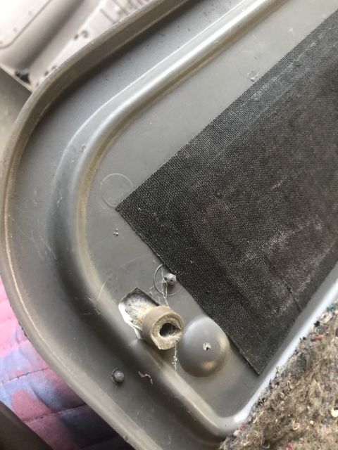 1995 Ford Bronco - Detail of interior door panel trim, showing a black fabric insert and a broken clip mechanism.