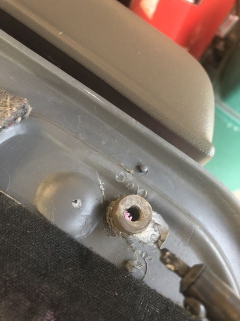 1995 Ford Bronco - Close-up view of a vehicle's interior trim panel, showing a bolt and some pink residue.