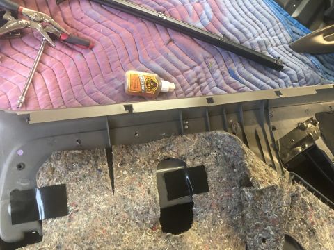 1995 Ford Bronco - A car's interior door panel is disassembled, revealing insulation and tools for repair.