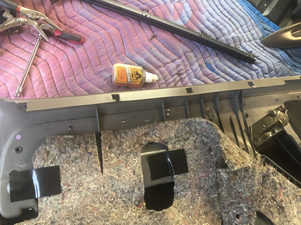 Car interior door panel with insulation and tools, including a bottle of Gorilla Glue