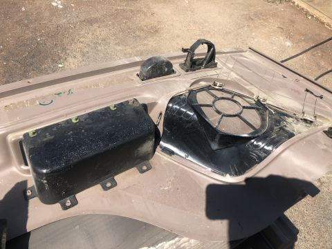 1995 Ford Bronco - Removed car interior door panel with speaker grille and a black housing unit visible.