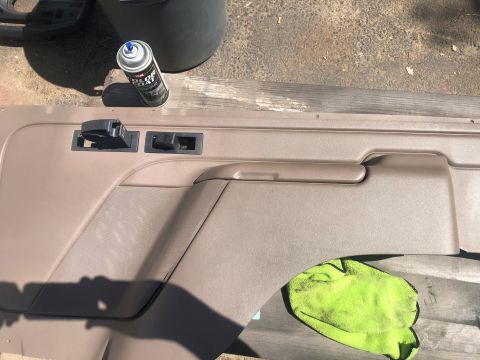 1995 Ford Bronco - A car door panel is shown with a spray can and a green microfiber cloth nearby.