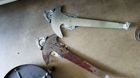 1994 Ford Bronco - Comparison of a clean and a rusty window regulator, likely for a vehicle door.