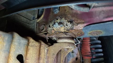 1994 Ford Bronco - Extensive rust damage is visible on the frame and suspension of this 1994 Ford Bronco.