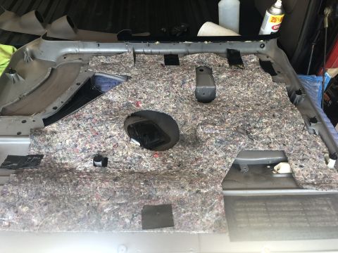 1995 Ford Bronco - The interior door panel of a vehicle is disassembled, revealing the internal components and sound insulation.