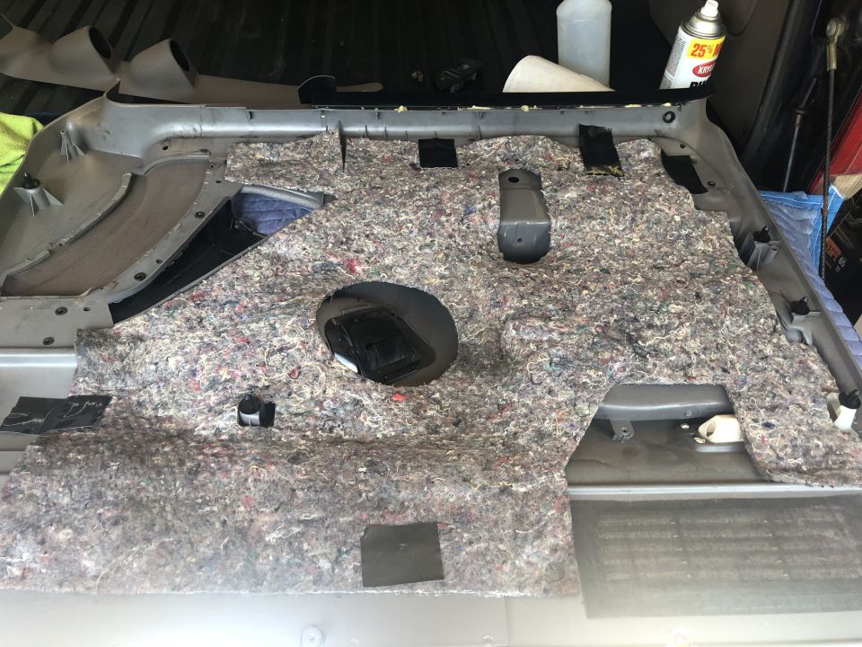 Car interior door panel with sound deadening material removed, showing exposed metal and wiring
