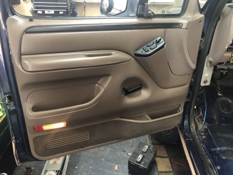 1995 Ford Bronco - Interior door panel and power window controls of a 1995 Ford Bronco.