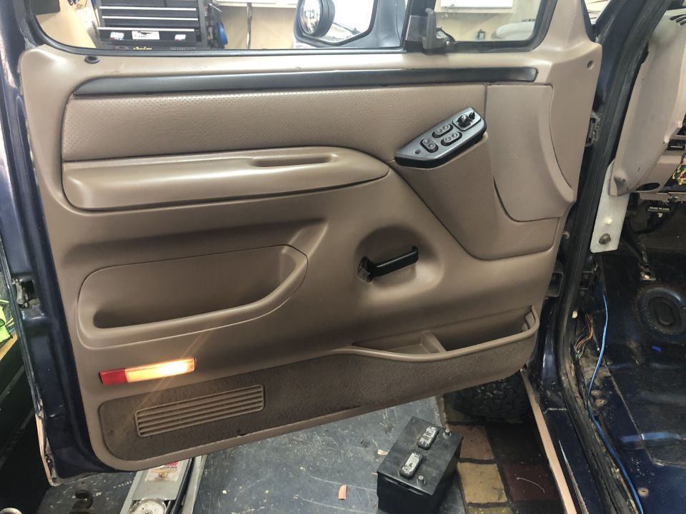 Tan interior door panel with power window controls in a 1995 Ford Bronco