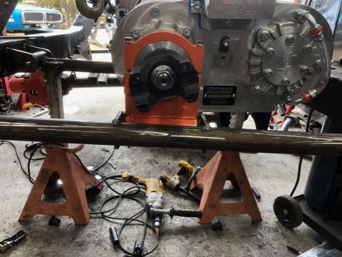 1992 Jeep Wrangler - A Jeep transfer case assembly is shown mounted on a frame section, supported by orange jack stands and surrounded by tools.