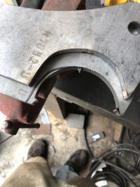 1992 Jeep Wrangler - A metal suspension component, marked with part numbers, is secured in a vise for inspection or work.