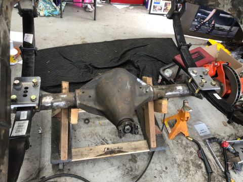 1992 Jeep Wrangler - A rear axle assembly, likely from a Jeep Wrangler, is shown supported by wooden blocks and jack stands in a workshop.