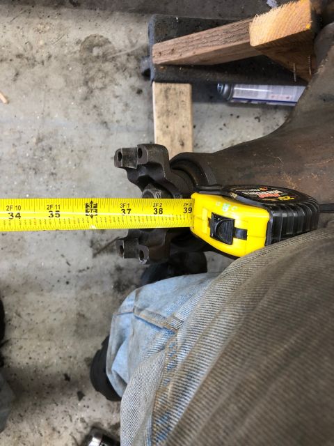 1992 Jeep Wrangler - A differential housing is measured with a yellow tape measure.