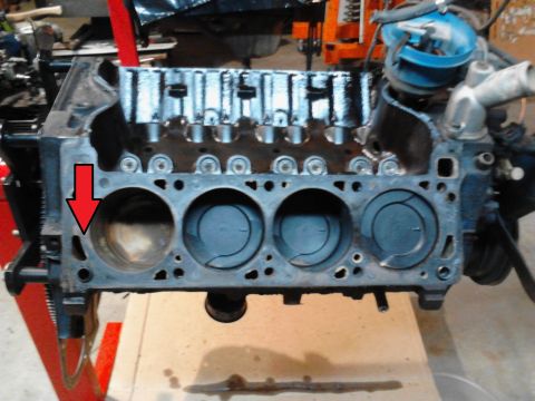 1978 Ford Bronco - Close-up view of an engine block, showing pistons within cylinders and a red arrow highlighting a cylinder bore.