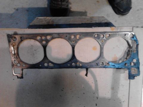 1978 Ford Bronco - Engine gasket with four cylinder openings, showing wear and blue sealant, with Supermotors.net logo in the corner.