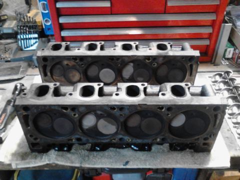 1978 Ford Bronco - Engine cylinder heads are shown on a workbench, with a toolbox visible behind them.
