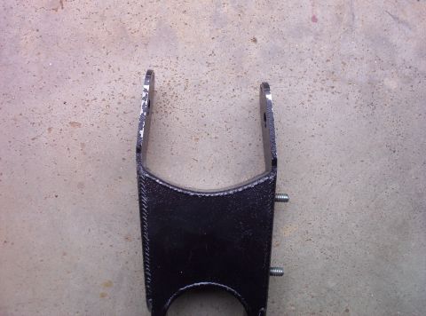 1995 Ford Bronco - A black metal automotive part is shown against a concrete background.