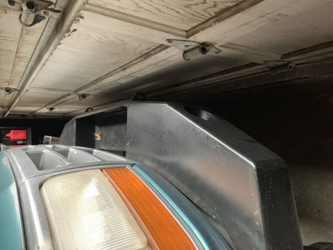 1996 Ford Bronco - Close-up of a teal 1996 Ford Bronco's front corner, showing the headlight and fender detail.