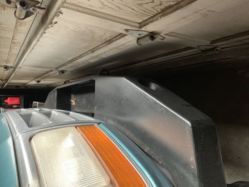 Teal 1996 Ford Bronco headlight and fender with a black plastic trim piece above