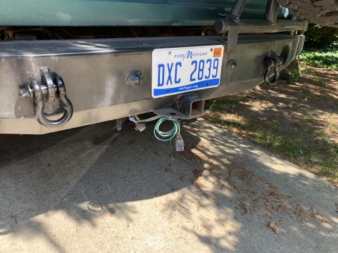 1996 Ford Bronco - The rear bumper assembly includes a tow hitch, shackle mounts, and a Michigan license plate.