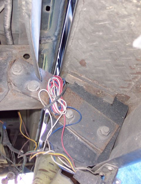 1992 Ford Bronco - Close-up view of wiring and structural components underneath a vehicle.