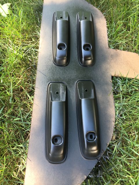 1996 Ford Bronco - Four black door handles are shown after being spray painted.