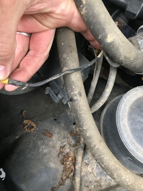 1996 Ford Bronco - Close-up of damaged wiring and corroded metal in a vehicle's engine compartment.