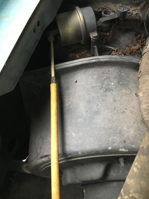1996 Ford Bronco - Close-up view of a vehicle's fuel tank and dipstick, showing mechanical components.