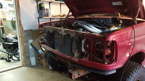 1994 Ford Bronco - This red Ford Bronco's front end is disassembled, revealing the radiator and engine bay.