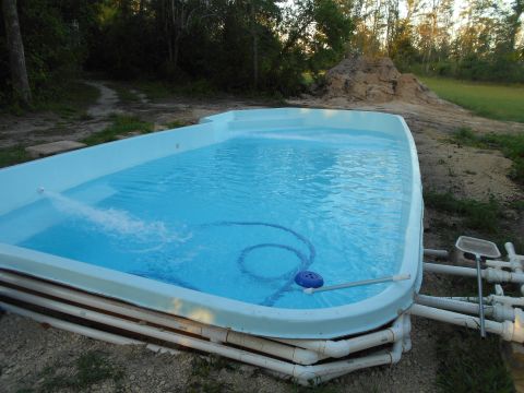 1992 Ford Bronco - Above-ground swimming pool with filtration system and pool cleaner hose visible.