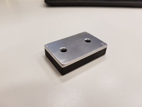 1978 Ford Bronco - A metal and rubber part with two holes is shown on a desk.