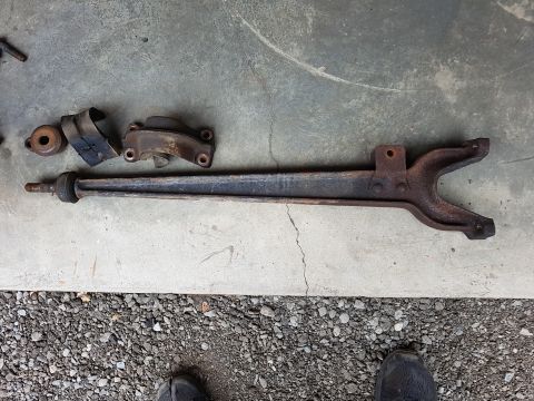 1978 Ford Bronco - Several rusty vehicle suspension components are laid out on a concrete surface.