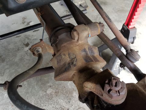 1978 Ford Bronco - This image shows a close-up view of heavily rusted vehicle steering and suspension components, likely from the front axle area.
