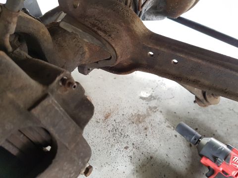 1978 Ford Bronco - Close-up of vehicle suspension components and a Milwaukee impact wrench on a workshop floor.