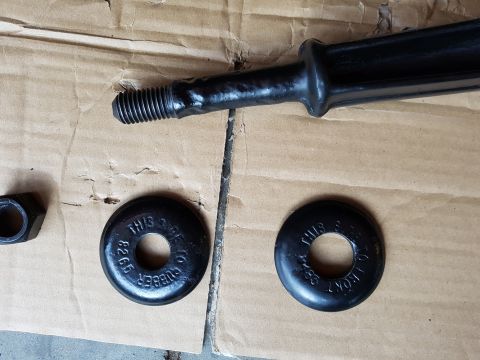 1978 Ford Bronco - Close-up of a black suspension component and two rubber bushings, one marked 'THIS SIDE TO FRONT' and '8265'.