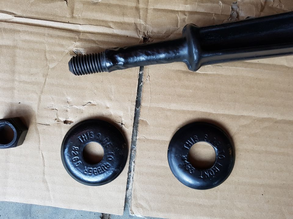 Black suspension part with rubber bushings marked 'THIS SIDE TO FRONT' and '8265'