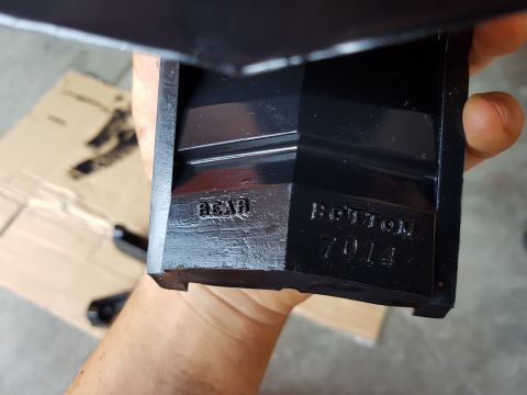 1978 Ford Bronco - Close-up of a stamped automotive part showing 'REAR' and 'BOTTOM 7014'.