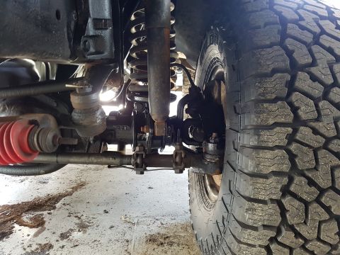 1978 Ford Bronco - Close-up view of a vehicle's front suspension and tire, with visible "SUPERMOTORS.NET" text on the tire sidewall.