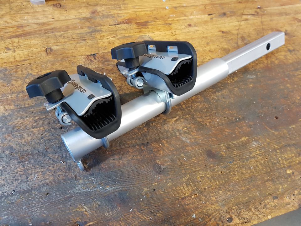 Silver bike rack part with two black and silver clamps