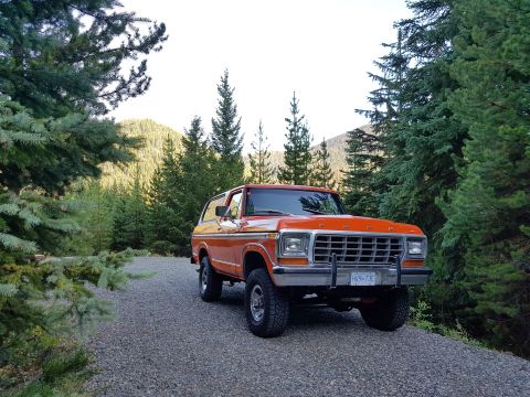 1978 Ford Bronco - This 1978 Ford Bronco is parked on a gravel road surrounded by trees and mountains.
